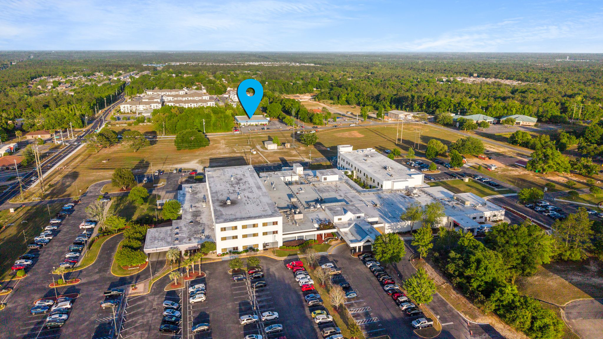 Drone view showing 577 Brookmeade in context with North Okaloosa Medical Center.