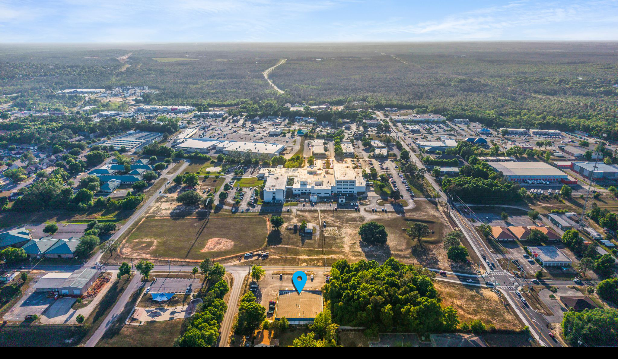 Aerial drone view of 577 Brookmeade Drive, Crestview, FL — exterior of the medical office building in context with the Crestview street grid and surrounding retail and medical infrastructure.